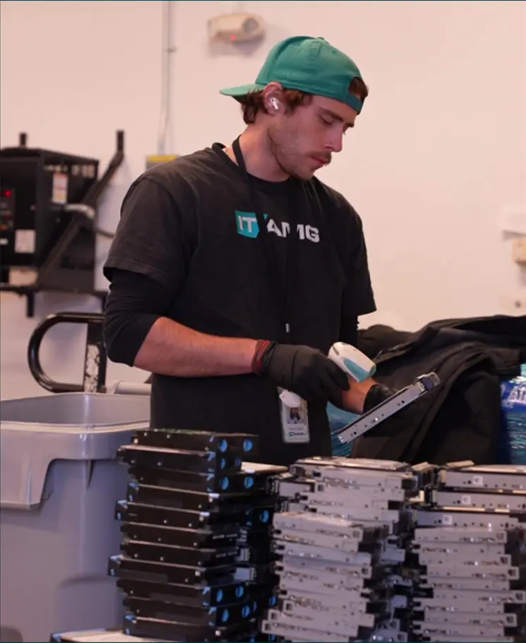 ITAD technician scanning hard drives for secure data destruction at ITAMG's ITAD facility in New York.