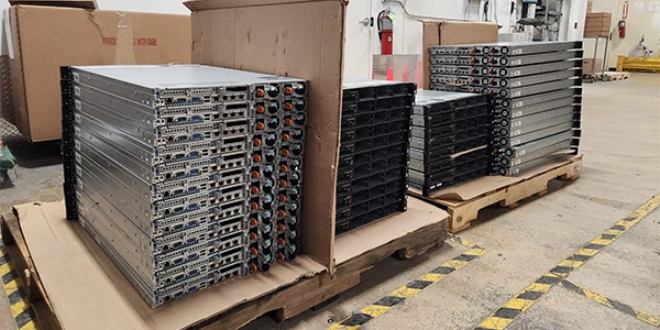 Decommissioned servers stacked on pallets, prepared for recycling in the warehouse